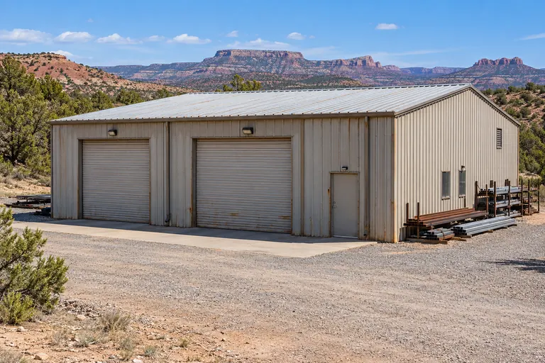 Metal shop building with a low-slope roof and a gravel yard